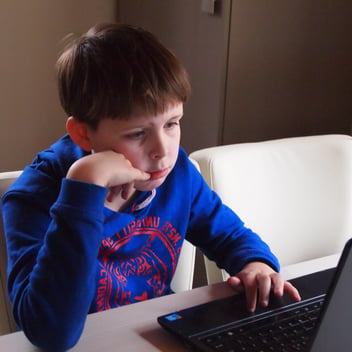 A young boy uses a laptop and looks pensive. From https://pixnio.com/people/children-kids/child-boy-internet-laptop-computer-technology-room-sit